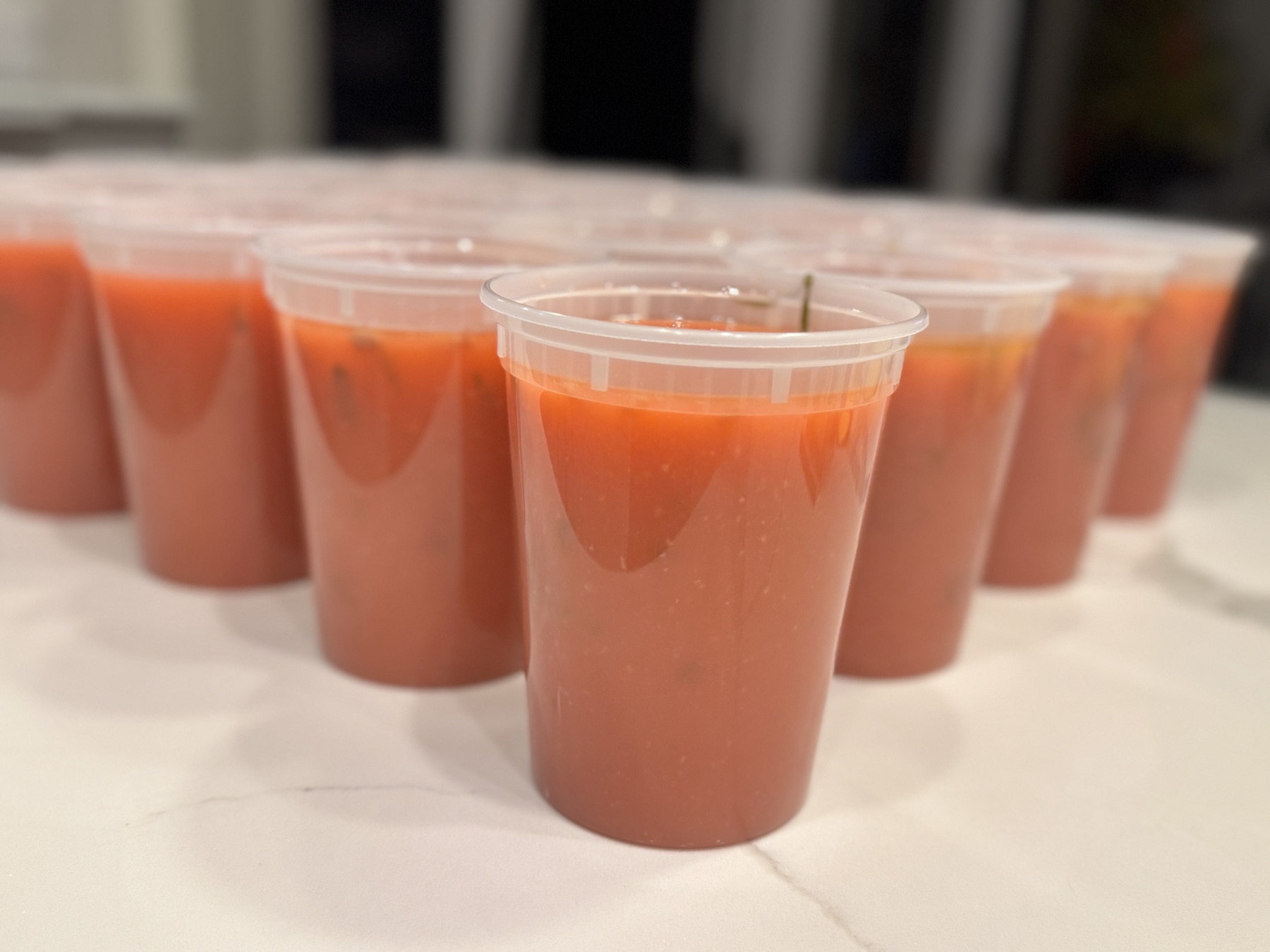 Dozens of portioned house-sauce cups lined up on the bakery counter